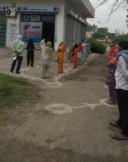 social distencing k saath grakj seva kendar cash leme pahuche log